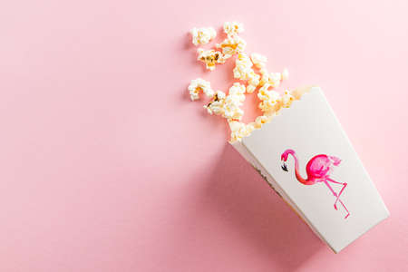 Popcorn in a paper box on a pink backgroundの写真素材