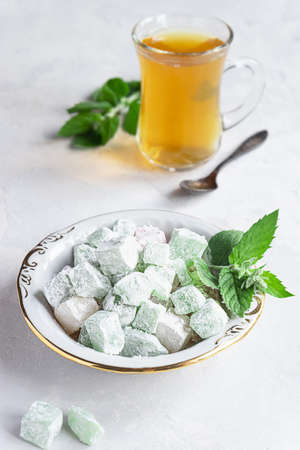 Turkish delight lokum on a plate with a glass of teaの写真素材