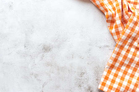 Checked orange tablecloth on grey concrete backgroundの写真素材