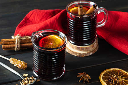 Two glasses of hot mulled wine on a dark wooden backgroundの写真素材