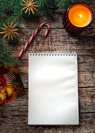 A white notepad on dark wooden background in Christmas settingの写真素材