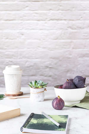 Creative workplace with a bowl of figs, side view.の写真素材