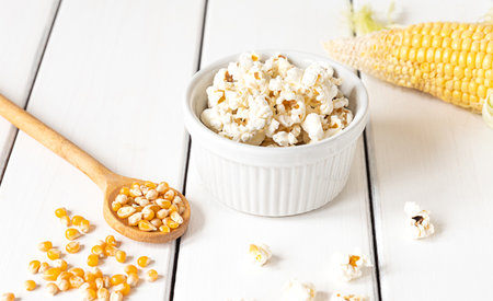 Popcorn, corn cob and corn grains, top view on a white wooden backgroundの写真素材