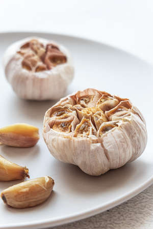 Roasted garlic on a grey plateの写真素材