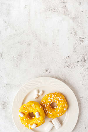 Two donuts with marshmallows served on a plateの写真素材