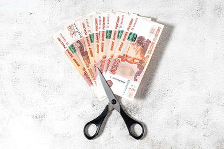 Russian rubles and scissors on a grey backgroundの写真素材