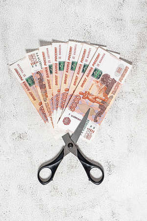 Russian rubles and scissors on a grey backgroundの写真素材