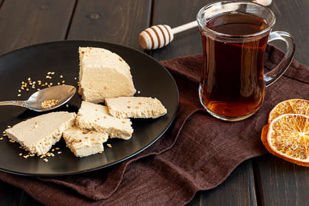 A glass of tea and tahini halva on a plateの写真素材