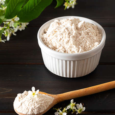 Birdcherry flour in a bowl on dark wooden backgroundの写真素材