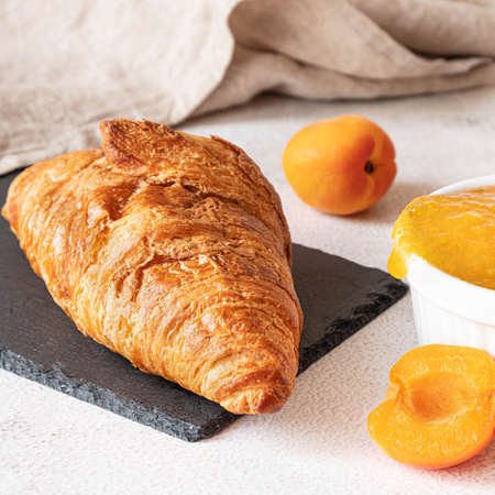Fresh croissant with apricot jam. French breakfast conceptの写真素材