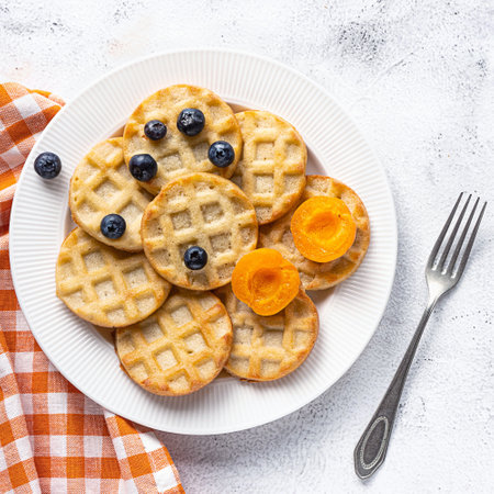 Small round waffles and fruits on grey background, flat layの写真素材