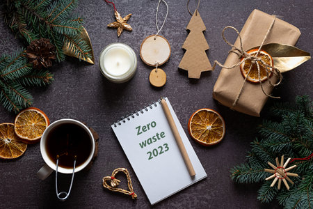 Eco-friendly and crafted Christmas decorations, fir branches, tea and a notebook on dark backgroundの写真素材