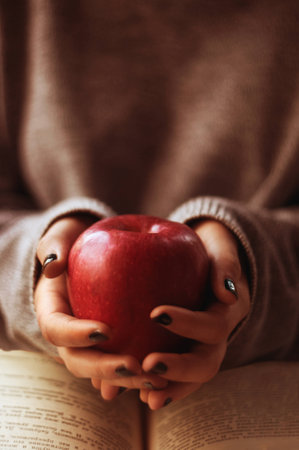 Young girl holding a red appleの写真素材