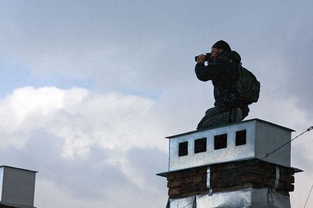The keen photographer on a roof of the house during a bad weatherの写真素材