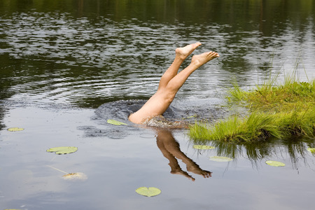 man diving to the forest lake, Russiaの写真素材