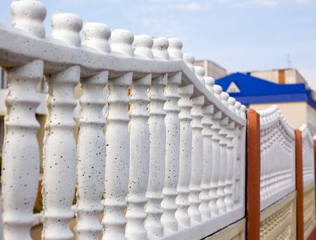 white stone laced fence and the blue roofの写真素材