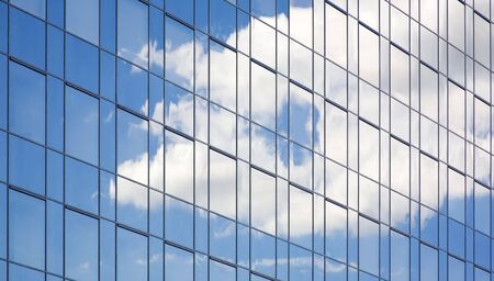 clouds' reflection in a glass building's wall