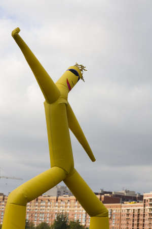 bright yellow inflatable figure supporting by air streamの写真素材