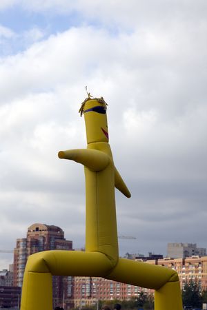 bright yellow inflatable figure supporting by air streamの写真素材