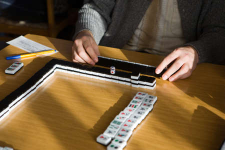 The player in mahjong behind a game tableの写真素材