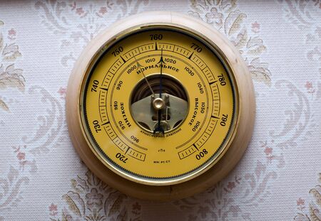 Yellow barometre against wall-paper with patternsの写真素材