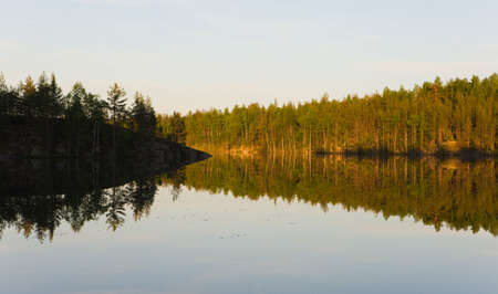 Coast of wood lake and its reflection at morningの写真素材