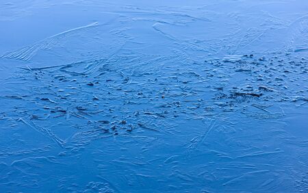 Thin blue ice on lake with patternsの写真素材