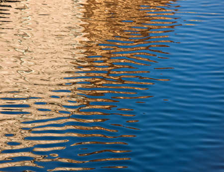 Abstract reflections in the river of gold and blue colorの写真素材
