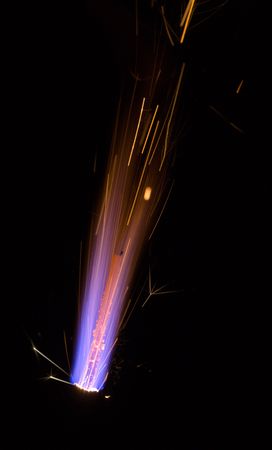 Burning violet fireworks on a black background
