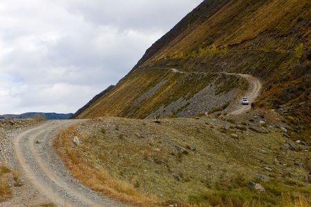 The car goes down from pass on narrow twisting roadの写真素材
