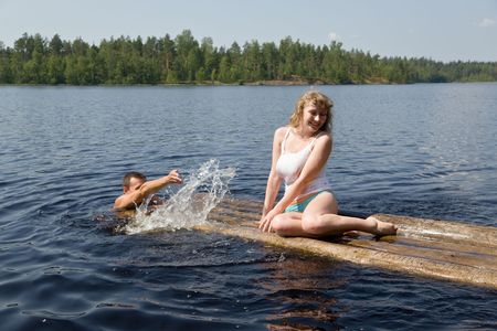 The man and the woman have a rest on lake in the summerの写真素材