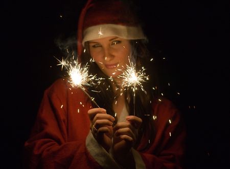 The girl in a suit of Santa Claus with Bengal firesの写真素材