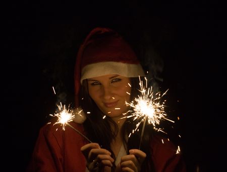 The girl in a suit of Santa Claus with Bengal firesの写真素材