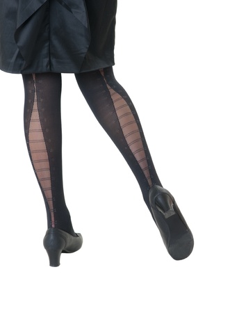 slim female legs in black stockings and shoesの写真素材