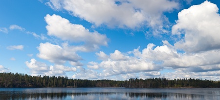 Cumulus clouds over wood lake in the springの写真素材