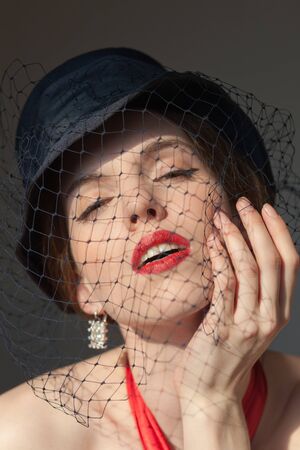 Portrait of the girl in a black hat with a veil