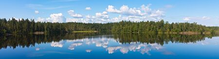 the wood lake in silent summer day with reflections of cloudsの写真素材