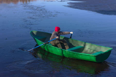 Girl in a boat at the spring lakeの写真素材