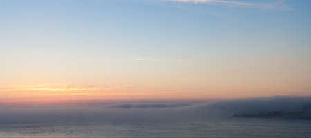 dense fog over the bay at sunsetの写真素材