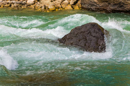 stone in the water fast mountain river