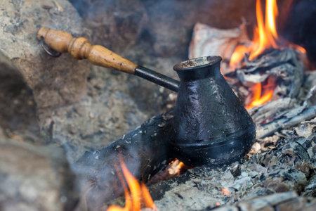 coffee in bronze cezve on charcoal fireの写真素材