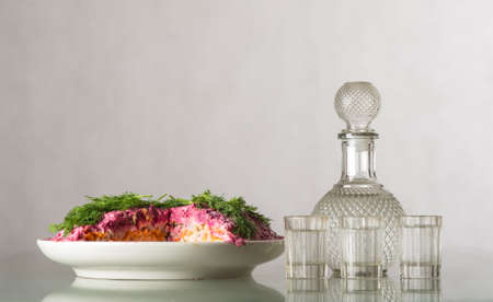Traditional russian salad, bottle and a cup of vodkaの写真素材