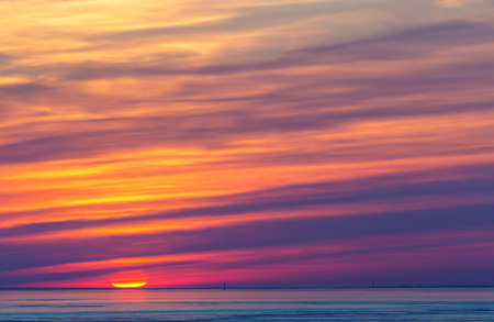 bright sunset with clouds, the sun on the horizonの写真素材