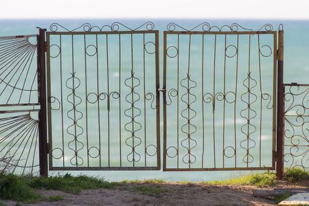 iron fence with a lock on the beachの写真素材