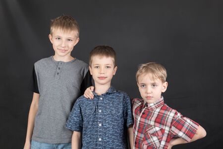 portrait of three brothers on a black backgroundの写真素材