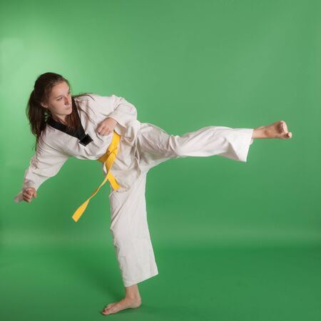 girl in kimono engaged taekwondo, studio shotの写真素材