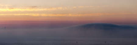 wave of fog over the bay at sunsetの写真素材
