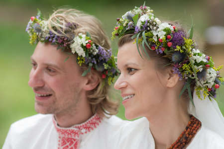 Portrait of newlyweds in wreaths close upの写真素材