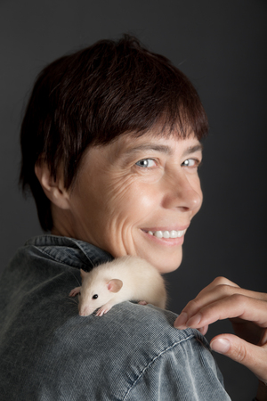 baby rat sits on the shoulder of the womanの写真素材