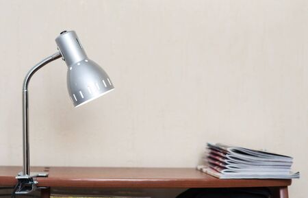 Lamp with a clothespin on the table with exercise booksの写真素材